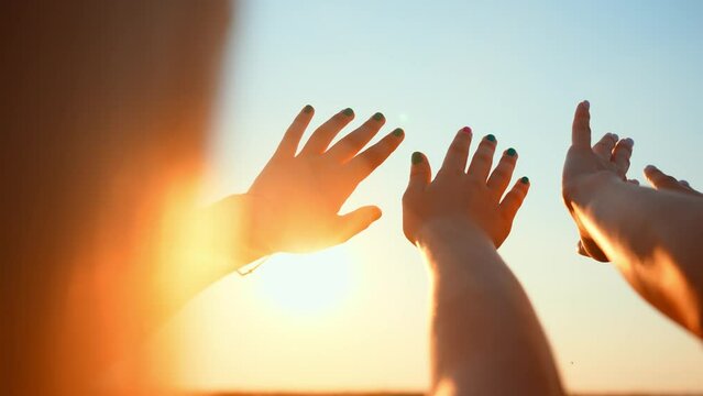 Close up many female hands raised up against blue sky. Friendly team. Gestures, symbols and signs. Participation in public vote. Swing arms to beat of music in dance. Sunny summer outdoor nature.