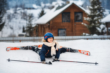 Little happy boy is learning to ski. Ski equipment, winter clothes. Active sports entertainment...