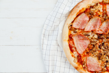 Fresh homemade sliced pizza on white wooden table, top view