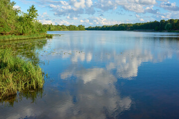 Landscape of the river with reflection of blue sky with clouds.