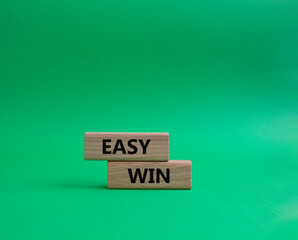 Easy win symbol. Wooden blocks with words 'Easy win'. Beautiful green background. Business and 'Easy win' concept. Copy space.