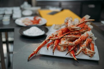 Fresh red Kamchatka crab legs on the table and ingredients in the restaurant kitchen.
