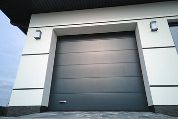 Automatic electric roll-up commercial garage gate or push-up door in modern private building ground...