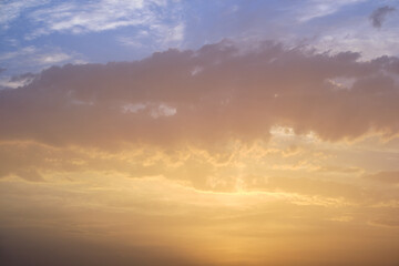 Dramatic bright red sky with orange-gray th.underclouds at sunset over a dark mountain forest landscape at golden hour