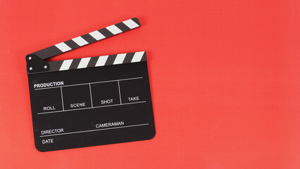 Black clapper board or movie slate on red background. - obrazy, fototapety, plakaty