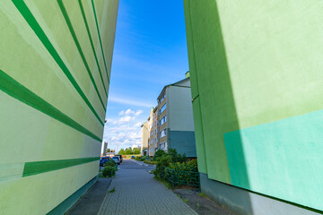City buildings photographed with a wide-angle lens against the sky. Artistic noise is present.