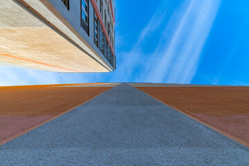 City buildings photographed with a wide-angle lens against the sky. Artistic noise is present.