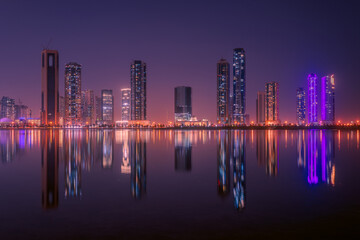 The tallest towers in the Emirates and their reflection on the lakes at night, Dubai, Sharjah