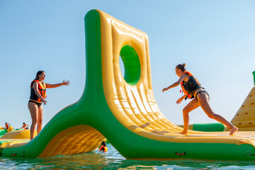 Inflatable bounce castle floating in water.Aqua park for children having fun in water park.Aquapark...