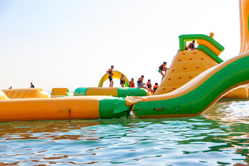 Inflatable bounce castle floating in water.Aqua park for children having fun in water park.Aquapark...