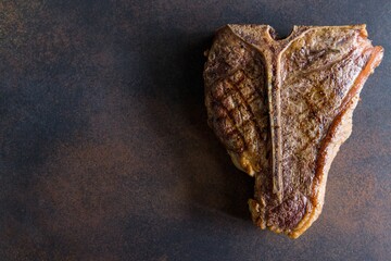 Steak T Bone, tibon steak, steak on bone dark brown table macro close up top view with copy space for text