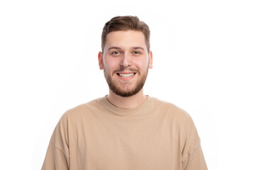 Fototapeta premium Happy caucasian male with bristle in stylish sweater standing indoors with sincere smile. Portrait of young joyful man expressing positive emotions in studio.