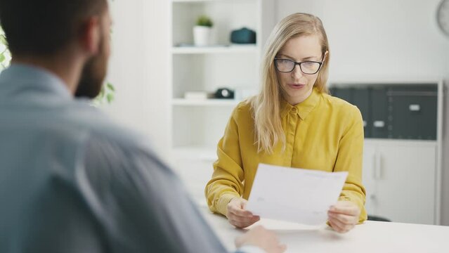 Young man as employee candidate has interview talk with woman boss in office