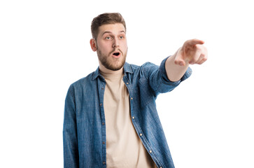 Amazed bearded man pointing his forefinger ahead while standing in studio with white background. Embarrassed caucasian male showing something shocking.