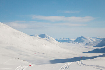 A skiing Kungsleden trail descending from Tjaktja mountain pass towards Salka mountain hut, winter season, Lapland, Sweden