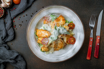 Salad caesar with chicken on plate on brown table top view