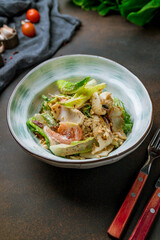 Salad with seafood on bowl on brown table, vertical