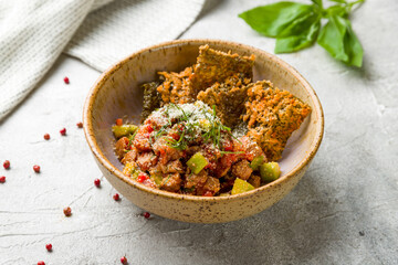 Tuna tar tar with avocado on bowl on grey table