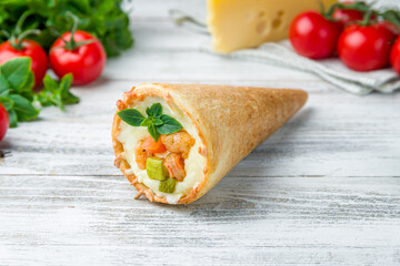 pizza in a cone with shrimps, zucchini, basil and cheese on white wooden table