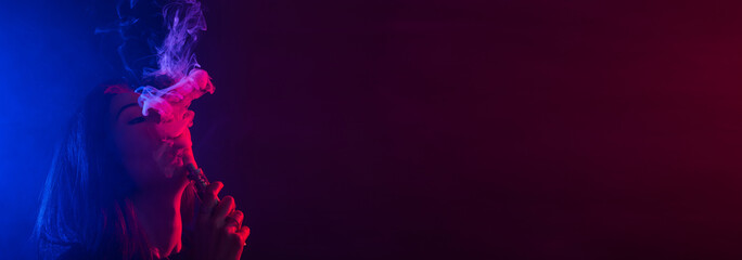 Banner asian woman in neon light and smoke of e-cigarettes or vape on dark background copy space
