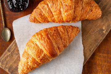 Two Croissants on Cutting Board with Blueberry Jelly and Spoon