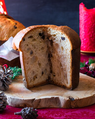 Panettone, pan dulce típico italiano sobre madera y mantel rojo.