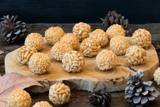 Dulces t&iacute;picos del D&iacute;a de Todos los Santos con pi&ntilde;ones y almendra. Panellets sobre madera.