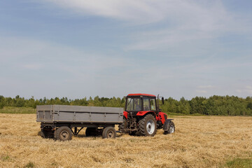 Red tractor with trailer in field