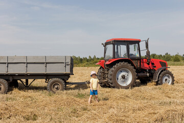Child and red tractor with trailer