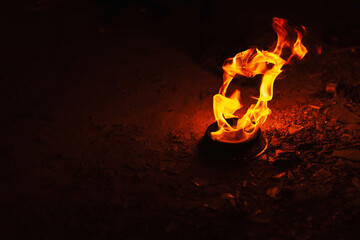 orange fire on a dark background. Burning kerosene in an iron plate. a burning torch for fire show...