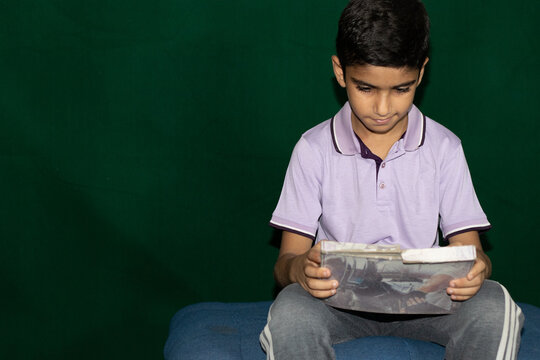 A boy sitting on counch with tablet computer