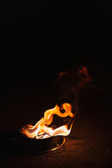 orange fire on a dark background. Burning kerosene in an iron plate. a burning torch for fire show...