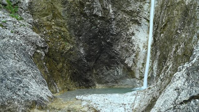 Clear water is flushing into a natural pool in the mountains