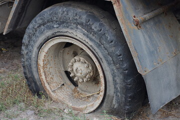 Fototapeta na wymiar one big black flat tire on a truck car on gray earth in the street