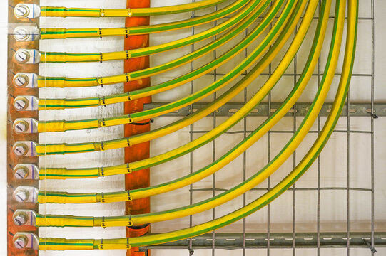 Electrical high voltage ground copper cables on wall. Grounding electric bar. Cables connected to electrical grounding bar. Ground industry for control system