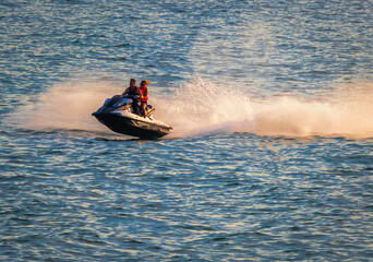 strong man drive on the jet ski above the water at sunset .silhouette. spray. in Bournemouth England