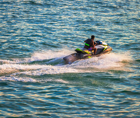 strong man drive on the jet ski above the water at sunset .silhouette. spray. in Bournemouth England