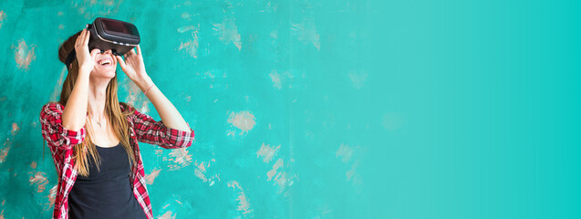 Banner technology, entertainment and people concept - happy young woman with virtual reality headset or 3d glasses copy space