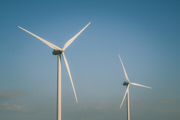 Wind turbines generating electricity with blue sky - renewable energy conservation concept. Wind...