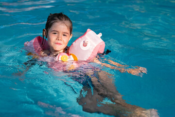 Une petite fille dans une piscine en été pendant les vacances