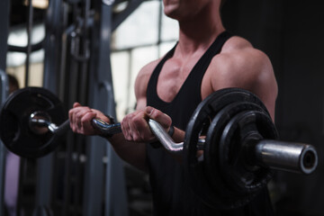 Cropped shot of a muscular bodybuilder training with ez curl bar