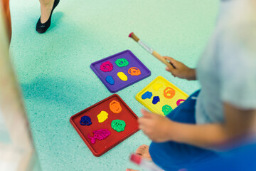 Nursery school. Toddlers having art game class, using washable, non-toxic paints and brushes. Fun art activity for kids fine and gross skills, creativity and imagination development. High quality