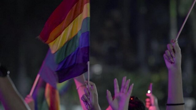 Manos y banderas en la noche PRIDE LGBT 