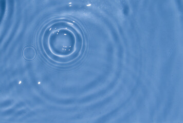 Flow of water is pouring on rippled water surface. Abstract background. Copy space for your design - stock photo