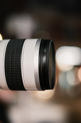 Fototapeta na wymiar Close-up shot of a photographic lens with bokeh at night