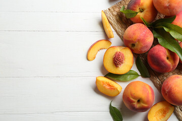 Fresh sweet peaches on white wooden table, flat lay. Space for text