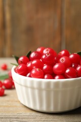 Tasty ripe cranberries on wooden table, closeup