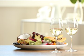 Delicious exotic fruits and wine on wooden table