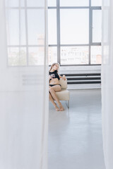 a girl in a torn T-shirt drinks wine in a spacious building