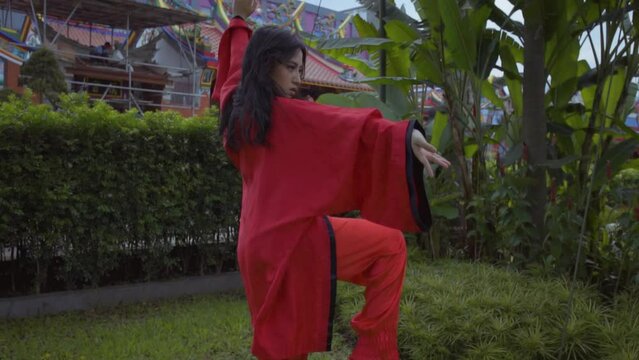 An Asian women practices martial art movement for the championship